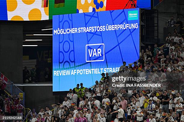 Giant screen informs about a VAR review during the UEFA Euro 2024 round of 16 football match between Germany and Denmark at the BVB Stadion Dortmund...