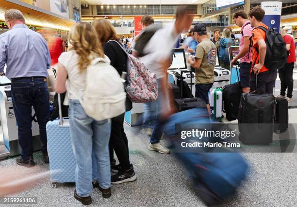 Travelers gather with their luggage in the international terminal at Los Angeles International Airport ahead of the July 4th holiday travel period on...
