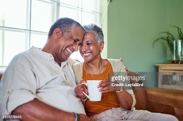 black senior couple, happy and with coffee in living room on couch for bonding, smile or relax. retirement, love and elderly man with mature woman together for marriage, anniversary and with beverage - man arm around woman on couch silhouette stock pictures, royalty-free photos & images