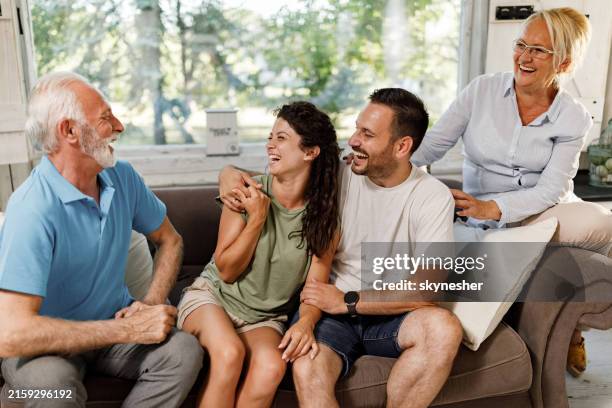 happy couple talking to mature couple at home. - schoonzoon stockfoto's en -beelden