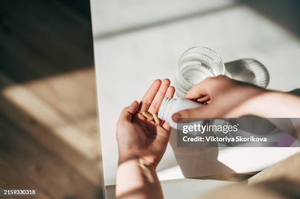 hand with pills and water glass - buikpijn stockfoto's en -beelden