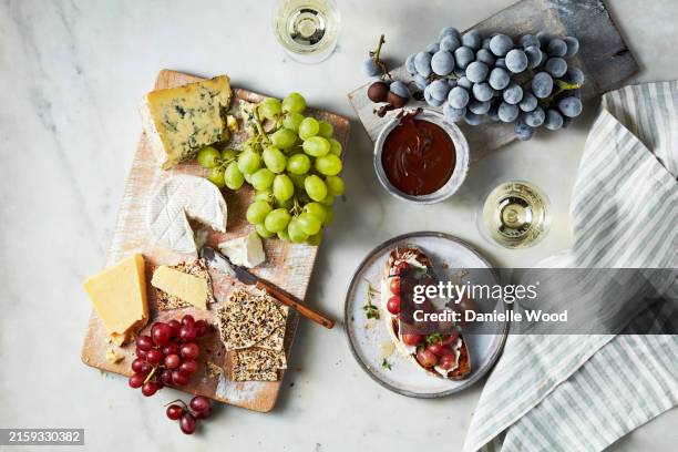 a gourmet cheese and fruit platter paired with wine on a leisurely afternoon - käseplatte stock-fotos und bilder