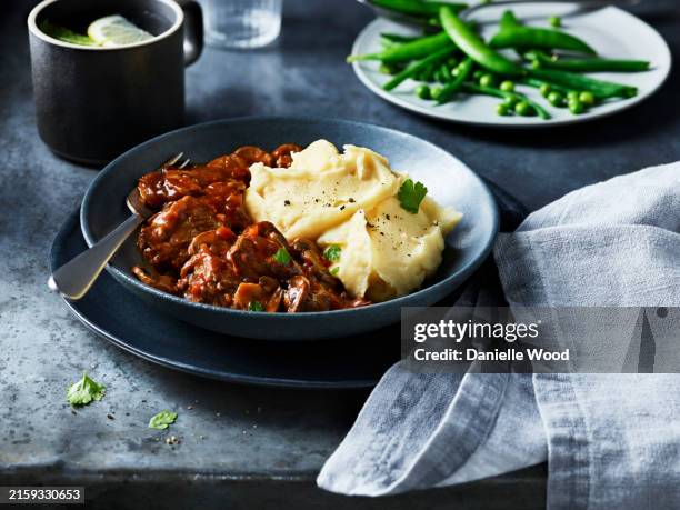 a hearty plate of beef stew with smooth mashed potatoes ready to be enjoyed - stew stock pictures, royalty-free photos & images