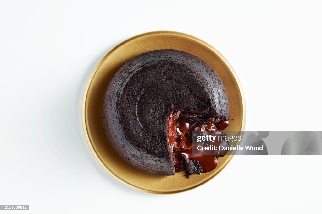 A delicious chocolate lava cake with a molten center on a golden plate