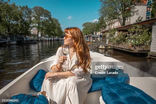 beautiful woman on a staycation amsterdam canal boat ride - amsterdam stock pictures, royalty-free photos & images