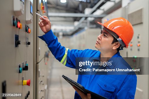 Power Engineer Utilizing Tablet for Real-Time Data in Control Room. Digital technology in maintaining and improving power systems. Power Engineer Utilizing Tablet for Real-Time Data in Control Room. Digital technology in maintaining and improving power systems.