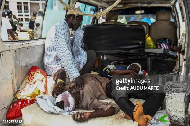 Injured men lay in a van as they arrive for treatment after a wave of suicide attacks in the North East of Nigeria, in Maiduguri on June 29, 2024. At...