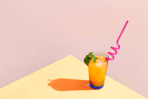 fresh orange cocktail with straw and a sprig of mint - orange cocktail stock pictures, royalty-free photos & images