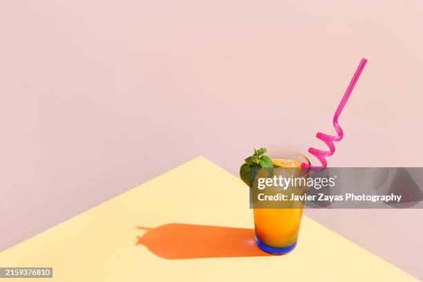 fresh orange cocktail with straw and a sprig of mint - juice bar stock pictures, royalty-free photos & images