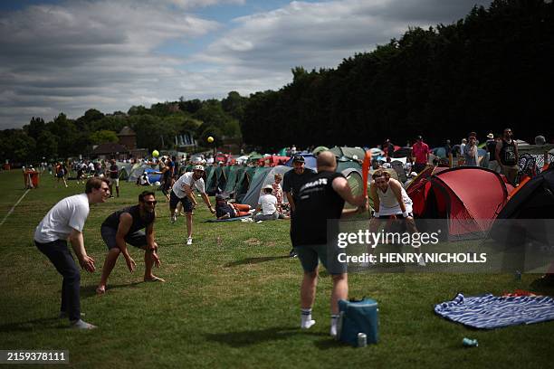 Fans play cricket by tents, as they camp in The Queue, on the eve of the 2024 Wimbledon Championships at The All England Lawn Tennis and Croquet Club...