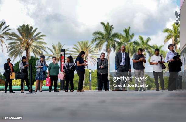 People line up as they wait for the JobNewsUSA.com South Florida Job Fair to open at the Amerant Bank Arena on June 26 in Sunrise, Florida. More than...