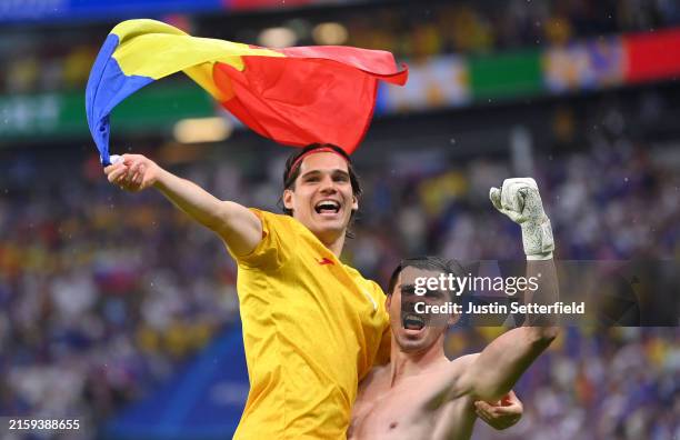 Ianis Hagi and Florin Nita of Romania celebrate with a Romania national flag after the team's qualification to the knockout stages following the UEFA...