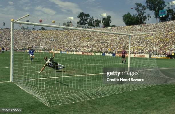 Italian footballer Roberto Baggio sees his penalty clear the bar as Brazilian goalkeeper Claudio Taffarel dives during the penalty shootout that...