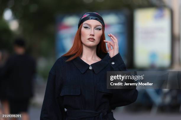 Meredith Duxbury is seen wearing a dark blue headscarf with blue/pink abstract floral pattern and a dark denim coat with waist belt from Giorgio...