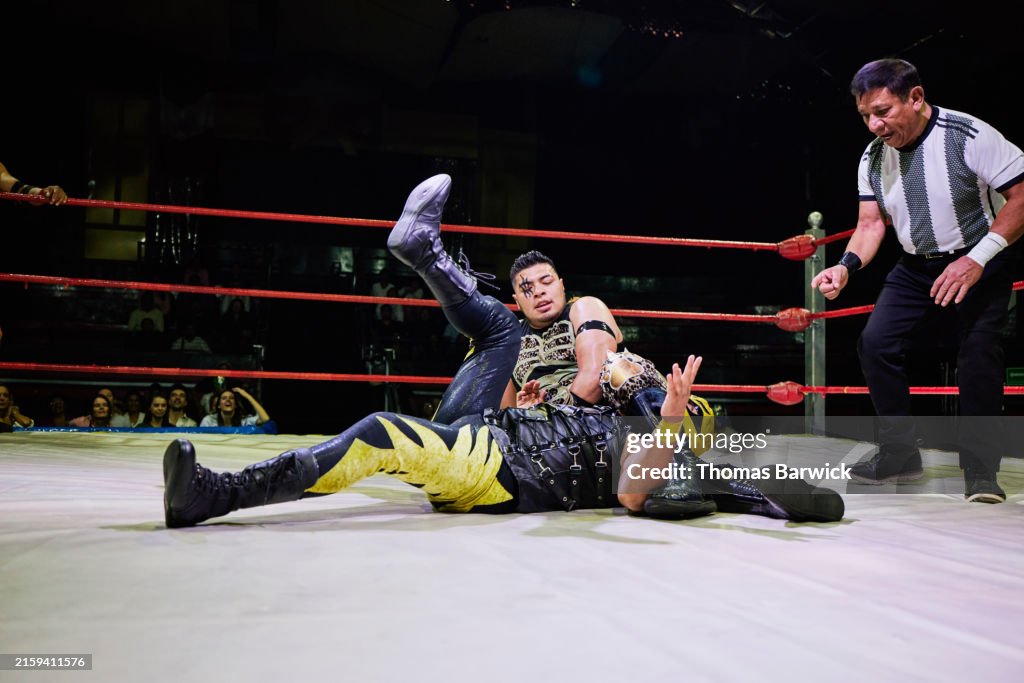 Wide shot of luchador trying to pin opponent during lucha libre match