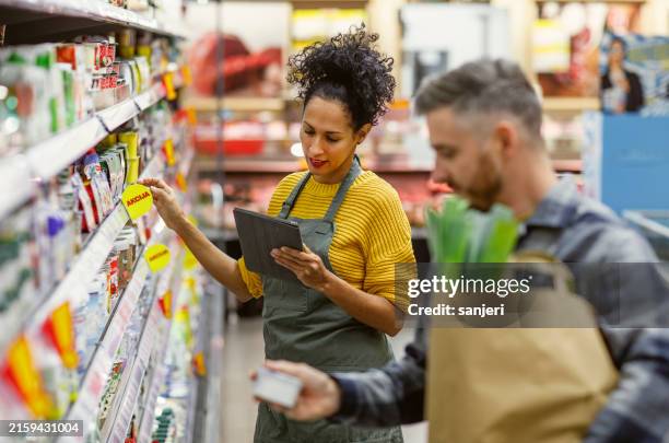 diligent hispanic shopping assistant in store aisle - inventory management stock pictures, royalty-free photos & images