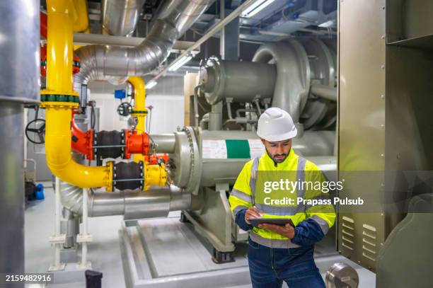 industrial engineer checking the pipeline tube of industry cooling tower for supply to air conditioner and water cooling tower air chiller hvac of huge industrial. - compressor stockfoto's en -beelden