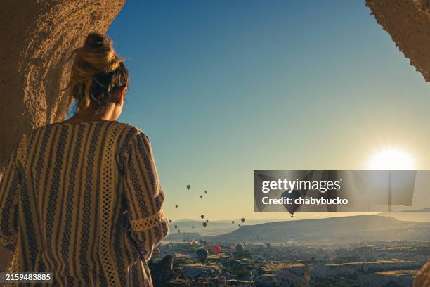 female tourist watching hot air balloons in cappadocia - capadócia imagens e fotografias de stock