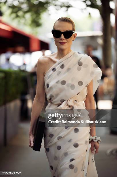 Renata Litvinova wears a white one-shoulder long maxi dress with big grey polka dots or circles, sunglasses and a black bag outside Balenciaga during...