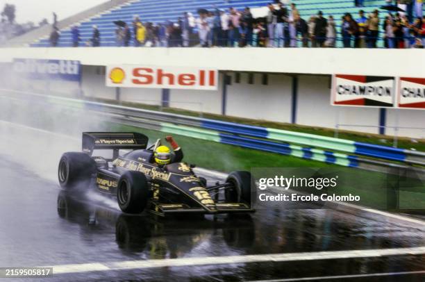 Ayrton Senna, Lotus 97T Renault, celebrates as he crosses the finish line and takes the chequered flag to secure his maiden F1 win during the...