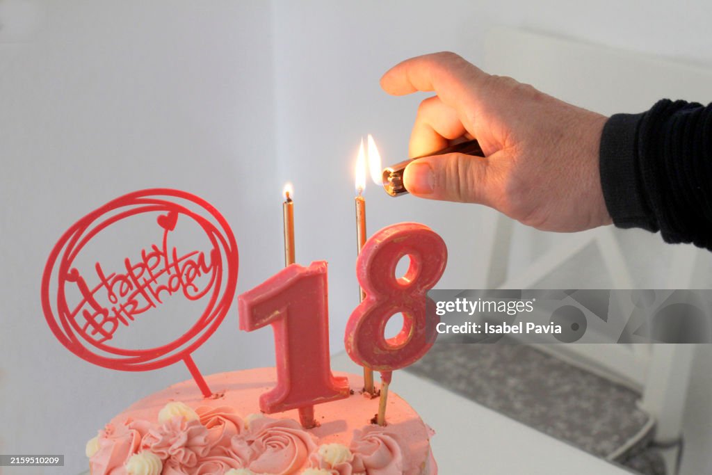 Hand burning 18 birthday candles with a lighter