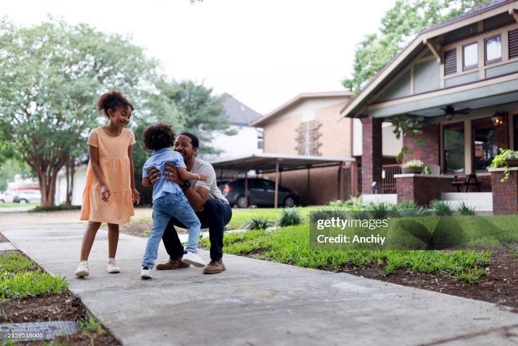 Carefree siblings playing with their parent outdoors