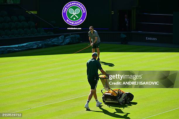 Groundstaff prepare the grass on Centre Court on the first day of the 2024 Wimbledon Championships at The All England Lawn Tennis and Croquet Club in...