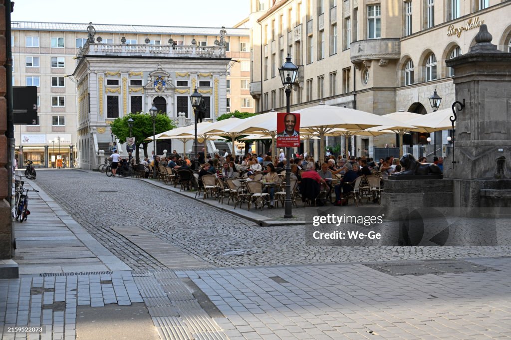 Open-air restaurant at the Naschmarkt in the old town of Leipzig, in the background the old stock exchange and the old town hall.