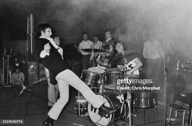 British guitarist Pete Townshend of The Who kicks his Fender guitar during their Germany Tour, April 1967; in the background, singer Roger Daltrey,...