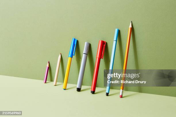 a group of pens and pencils leaning against a wall - inclusion sociale photos et images de collection