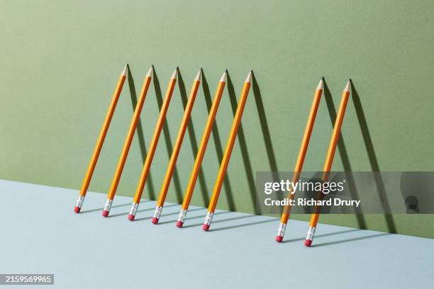 a group of pens and pencils leaning against a wall with one missing - system failure stock pictures, royalty-free photos & images