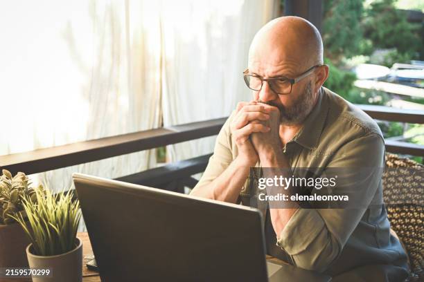 hombre adulto maduro con computadora portátil - estafador fotografías e imágenes de stock