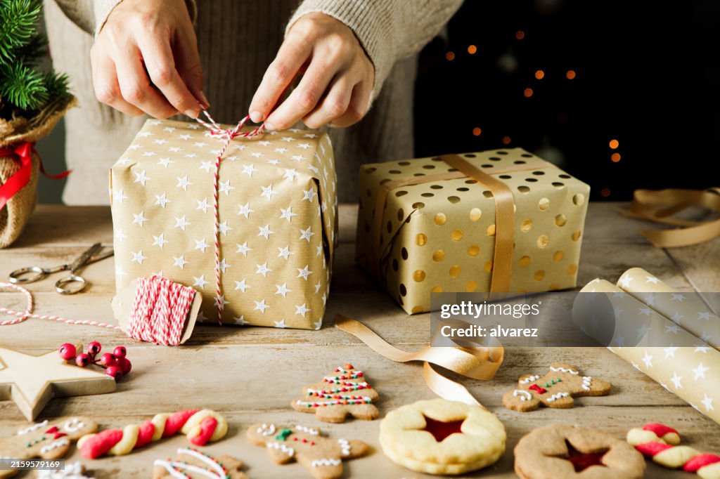 Woman hands tying a Christmas gift with a decorative string