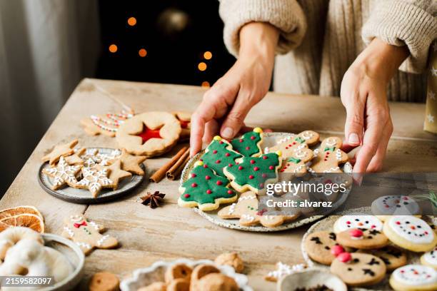 woman hands arranging sweets on christmas table - doces imagens e fotografias de stock