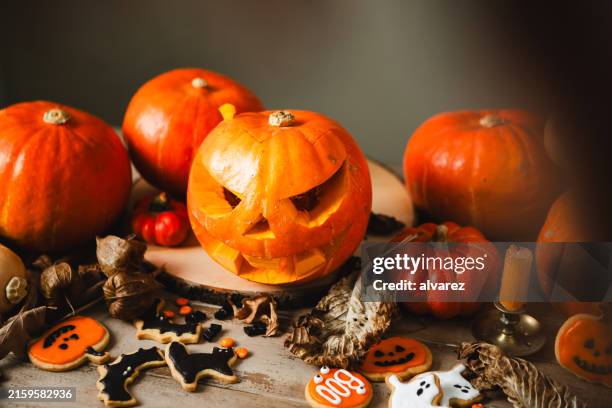 halloween festive table with jack o lantern pumkins and spooky cookies - carving stock pictures, royalty-free photos & images