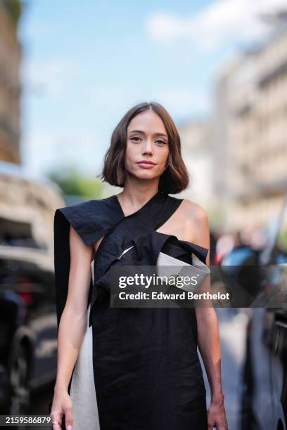 Guest wears black and white flowy midi Yohji Yamamoto dress, outside Stephane Rolland, during the Paris Haute Couture Week Fall/Winter 2024-2025 on...