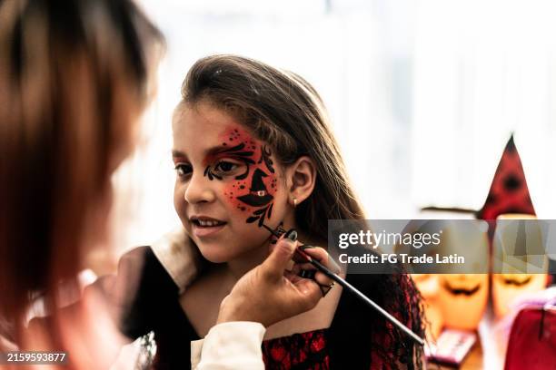 children girl doing halloween makeup at home - body art stock pictures, royalty-free photos & images