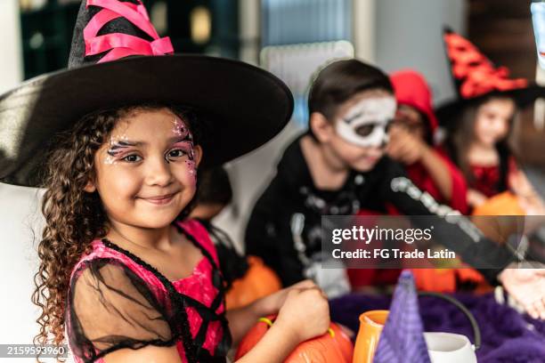 portrait d’une petite fille avec des amis utilisant le costume d’halloween à la maison - costume de scène photos et images de collection