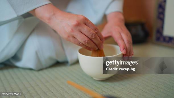 female japanese tea ceremony master preparing japanese matcha tea in tea ceremony room chashitsu - tea room stock pictures, royalty-free photos & images