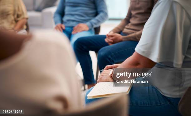a diverse group of individuals attends a support group meeting indoors. people are dressed in casual attire, sharing and listening attentively. the focus is on unity, support, and personal growth in a comfortable setting. - terapia-de-grupo imagens e fotografias de stock