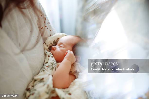 bonding moment: newborn girl asleep in mother's arms, captured up-close - postpartum depression stock pictures, royalty-free photos & images