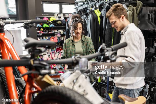 salesman helping customer in bike store - sports vendor stock pictures, royalty-free photos & images