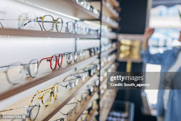 vue des étagères de présentoirs à lunettes dans un détaillant d’optique. - lunettes photos et images de collection