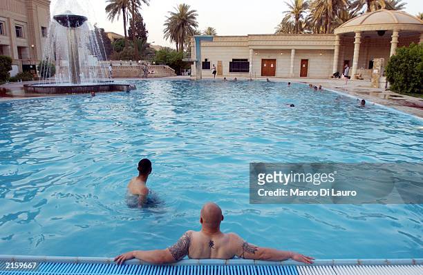 Off duty U.S. Soldiers enjoy Saddam Hussein's swimming pool at the Republican Palace July 14, 2003 in Baghdad, Iraq.