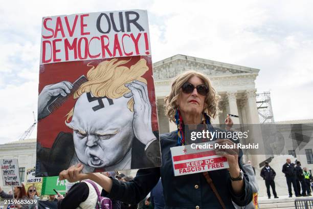 An activist holding a sign with Save Our Democracy written on it stands outside the US Supreme Court, as the court prepares to hear arguments on the...