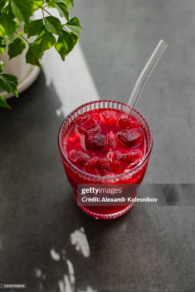 Delicious refreshing raspberry lemonade on dark background with shadow sunlight. Directly above with copy space