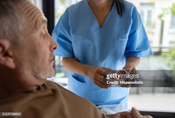 nurse explaining to a patient how to use an emergency button - panic button stock pictures, royalty-free photos & images