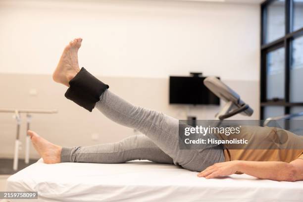 man in physical therapy lifting his leg using ankle weights - ankle weights stock pictures, royalty-free photos & images