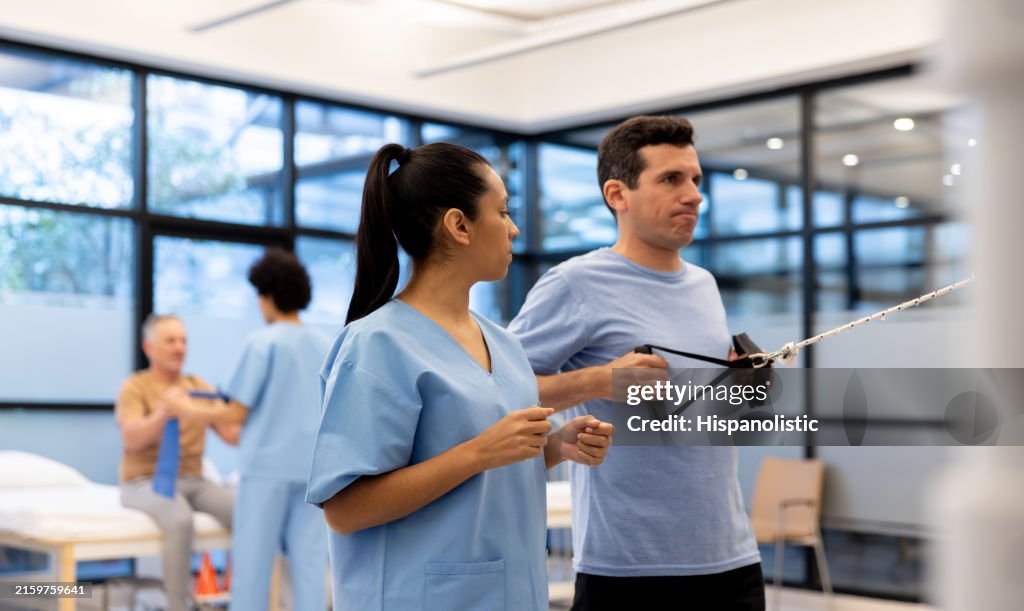 Physical therapist guiding a man exercising at a rehabilitation center