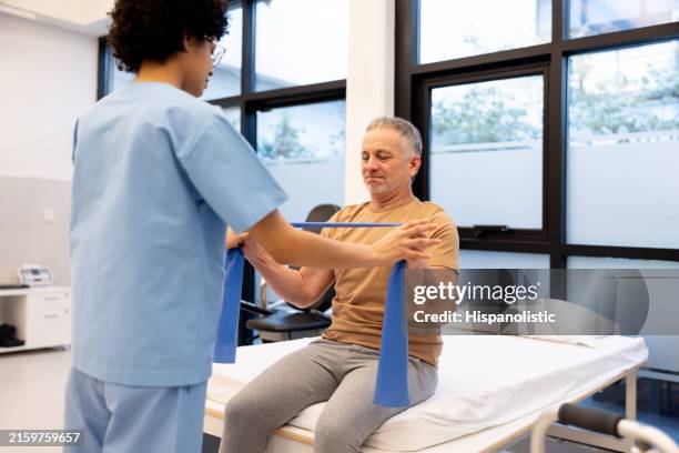 mature man doing strength training in physical therapy - neuropathy stock pictures, royalty-free photos & images